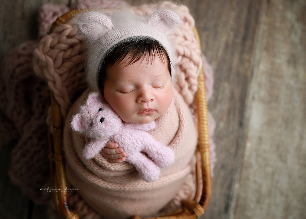 Baby girl snuggling bear in photo studio