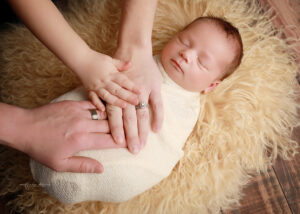 newborn with family's hands