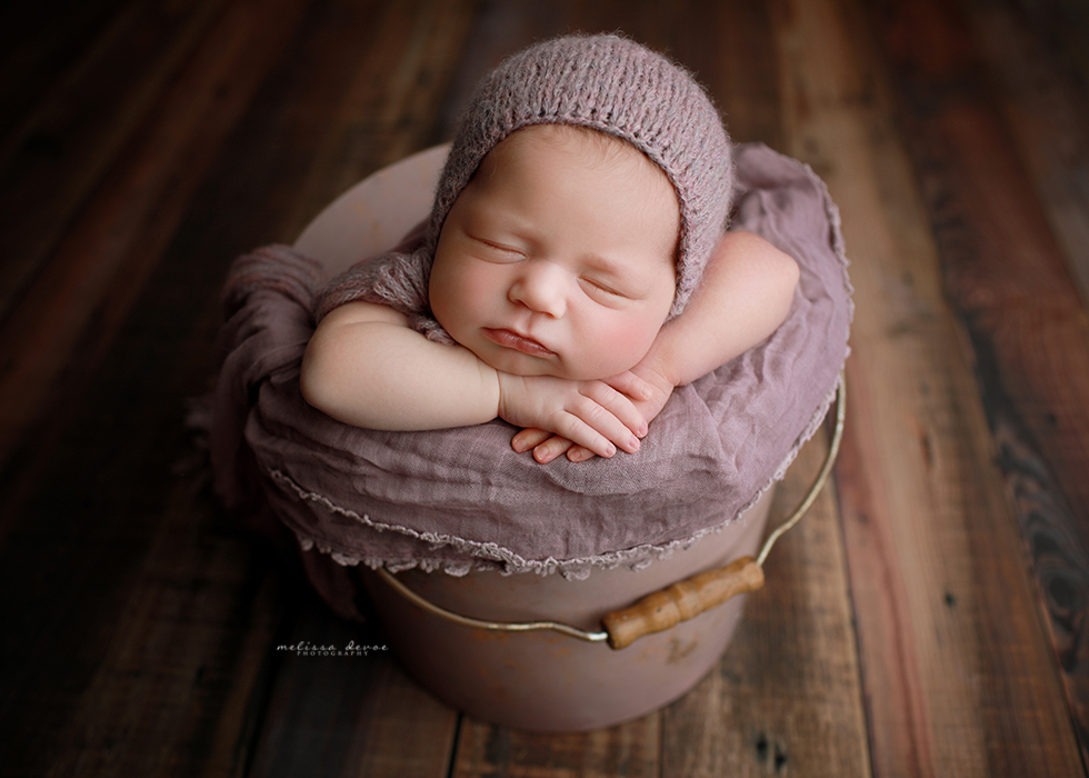 newborn posed in bucket