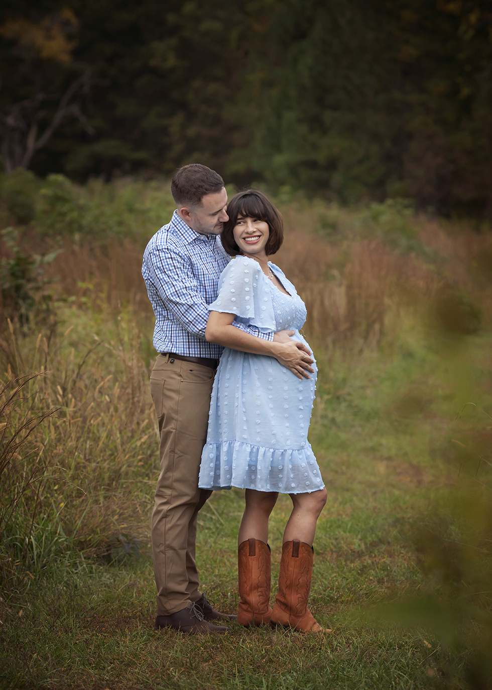Husband and wife at a park for maternity photo