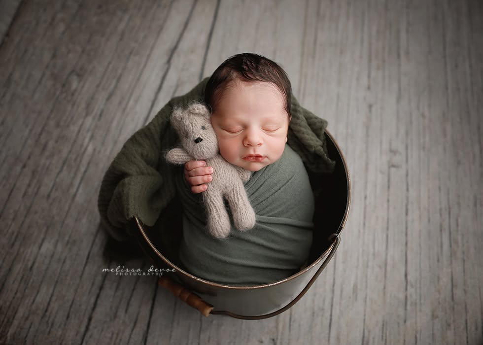 newborn holding bear