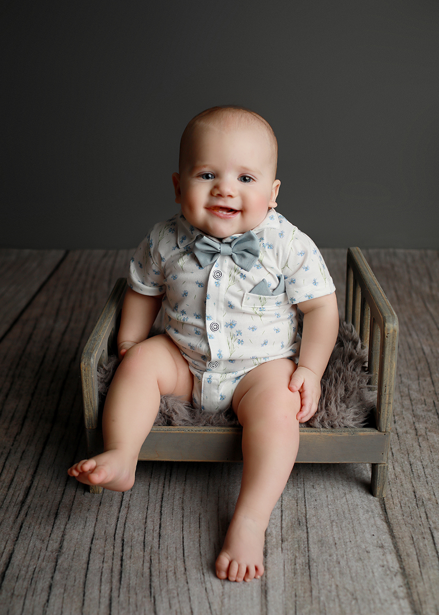Baby boy sitting on bed