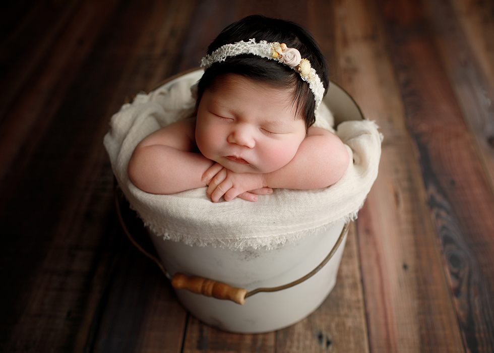 baby girl sleeping in bucket